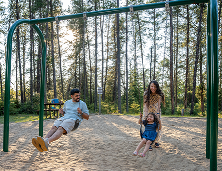 a family playing on the swings at a park